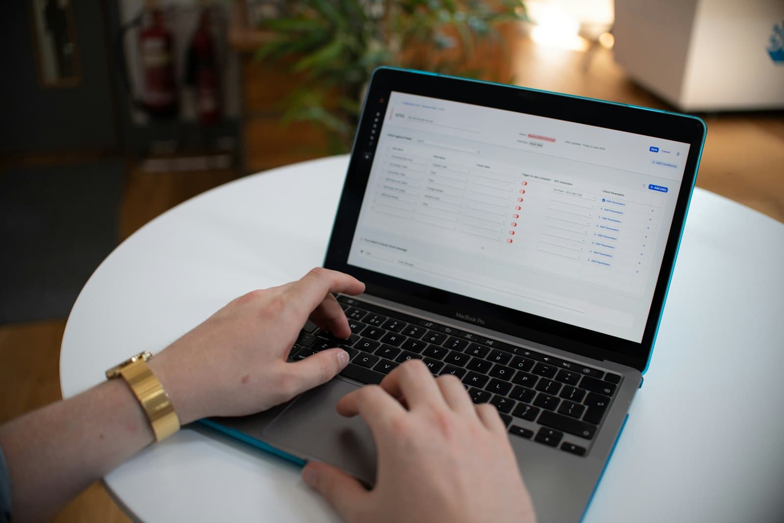 Hands typing on a laptop with business workflow data on screen